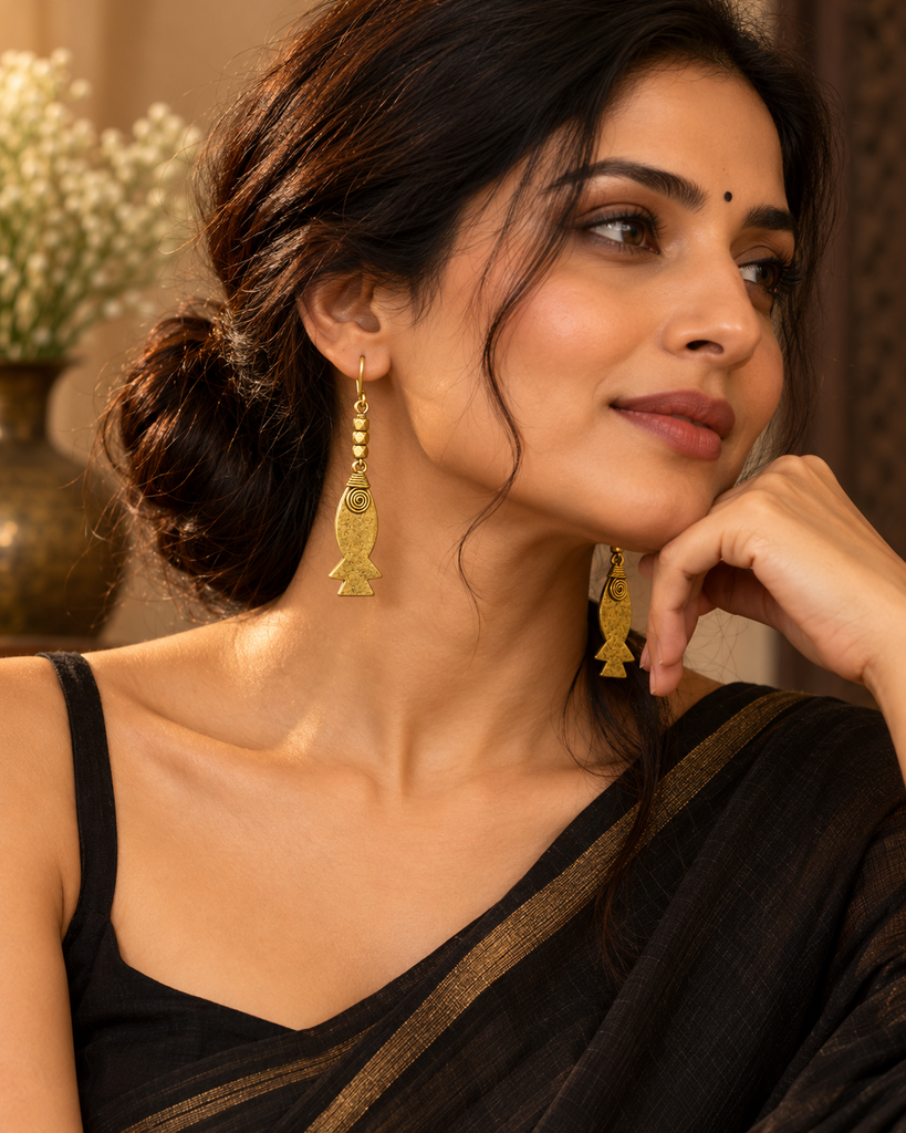 Indian woman wearing black attire with handcrafted brass fish earrings from LoomiQ.